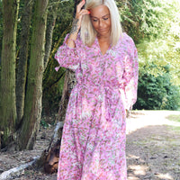 Woman wearing Rosalie bohemian floral-print pink cotton maxi kaftan//dress free size standing outdoors by trees in soft natural light, showcasing boho style cotton dress.