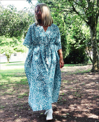 Woman walking outdoors wearing Eden bohemian printed cotton teal maxi kaftan//dress free size with a relaxed fit and intricate boho style patterns.