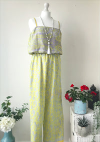 Layla yellow/lilac paisley-print silk jumpsuit free-size displayed on a white mannequin, styled with a long beaded necklace, set against a minimal background with floral accents.