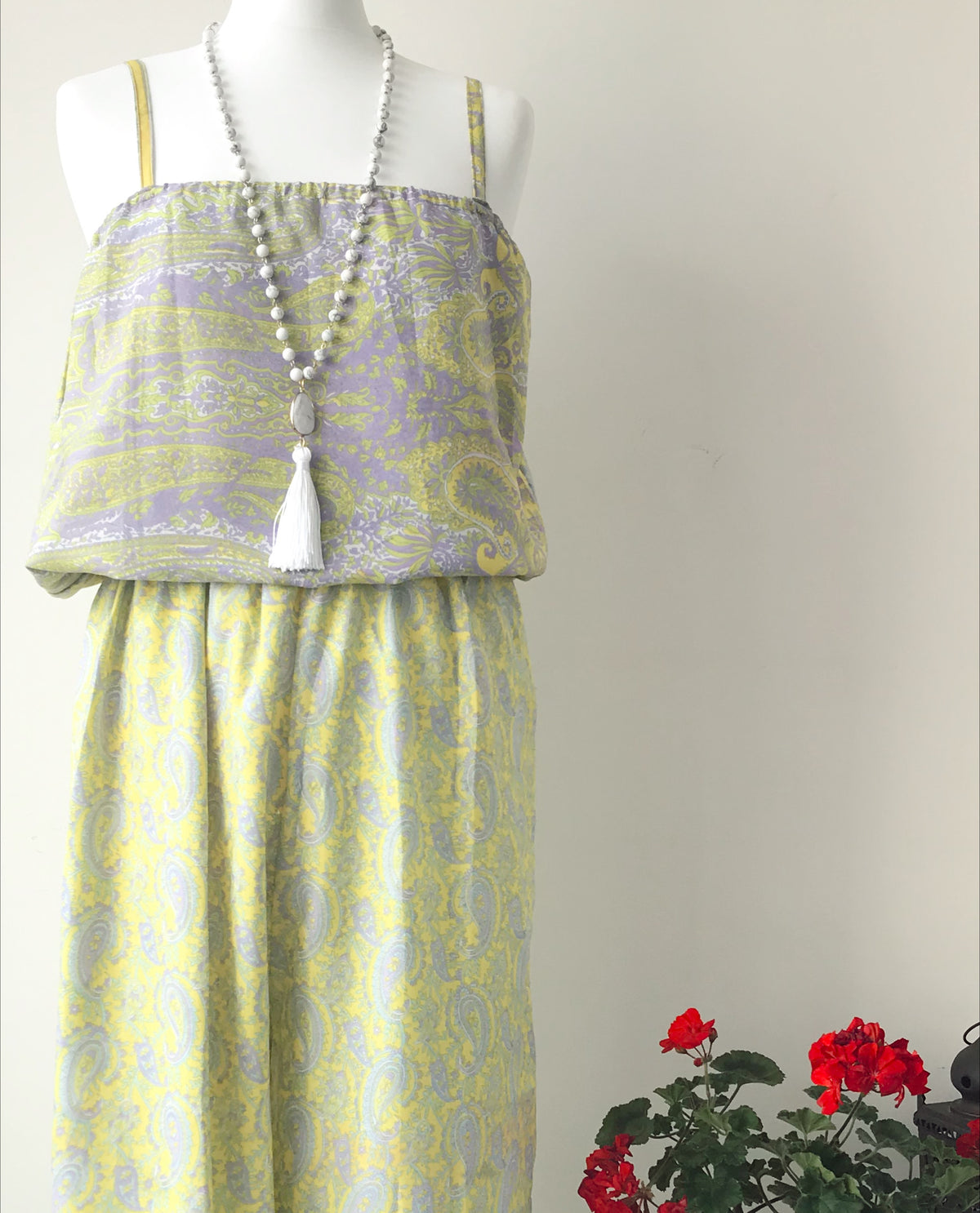 Layla yellow/lilac paisley-print silk jumpsuit free-size displayed on a mannequin, featuring delicate paisley patterns and a long beaded necklace with a white tassel.