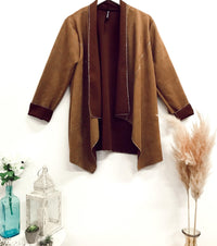 Faux-suede boho waterfall tan jacket with draped open front and relaxed fit, styled in a minimalist setting with boho decor accents.